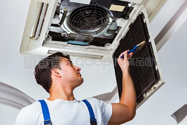 修理天花板空調(diào)設(shè)備的工人